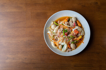 Top view of spicy Seafood Salad on a wooden table, Thai spicy food, Spicy salad, Copy space.