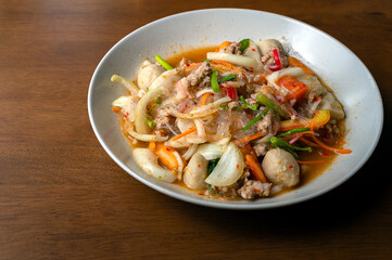 Top view of spicy Seafood Salad on a wooden table, Thai spicy food, Spicy salad, Copy space.
