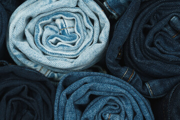 Large quantity of rolled up jeans in lots of shade of blue