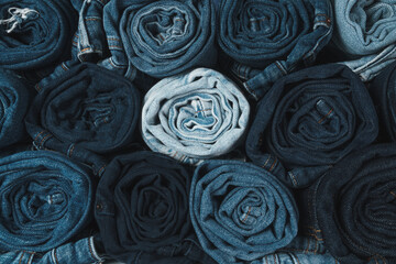 Large quantity of rolled up jeans in lots of shade of blue