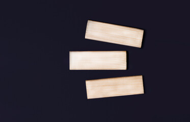 Three wooden blocks with space to insert text on a black background. copy space