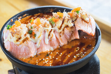 Grilled Salmon sushi with cream salad and spicy sauce placed on a Japanese grill, sushi is a traditional and popular food for Japanese people.