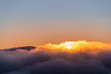 sun popping in the clouds at sunrise