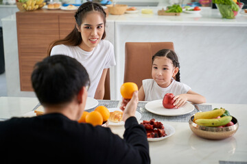 Duaghter and parent are enjoying to dinner or luanch on dinning table in home and kitchen