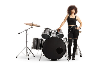 Obraz na płótnie Canvas Young female drummer standing next to a drum kit