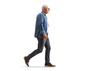 Naklejka premium Full length profile shot of a mature man in a denim shirt walking