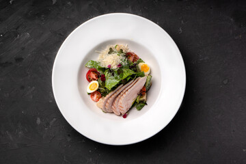 Salad with chicken fillet and vegetables on a white plate
