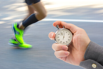 measuring the running speed of an athlete using a mechanical stopwatch. hand with a stopwatch on...