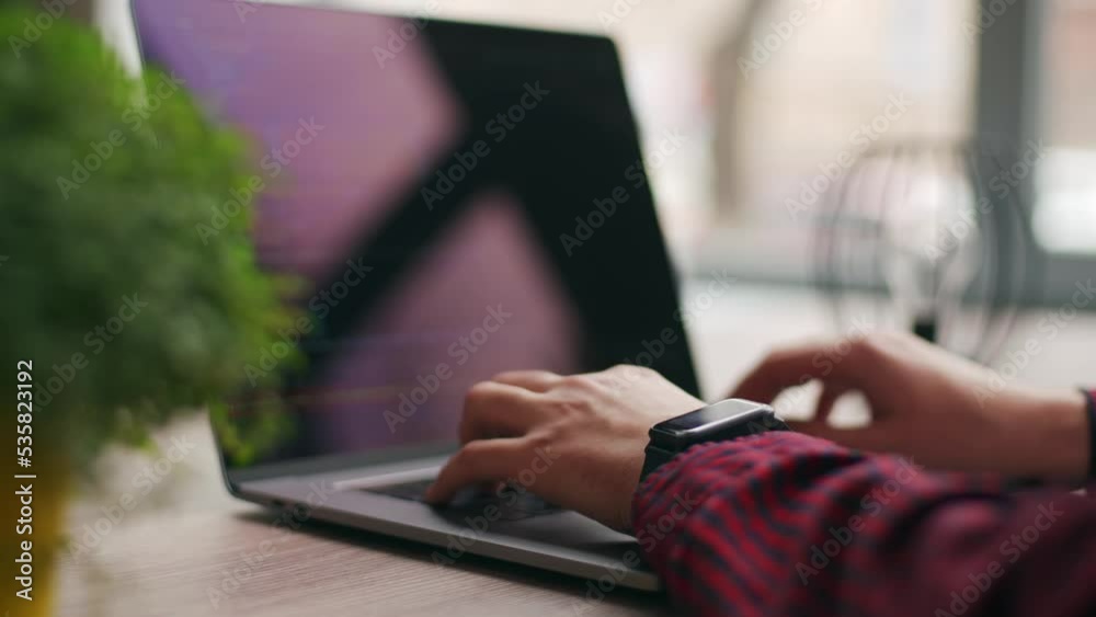 Wall mural close up of freelancer's hands typing code on laptop keyboard. camera slides around developer's fige