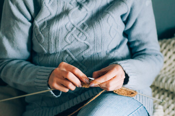 Women's needlework hobby knitting. Woman knits on knitting needles