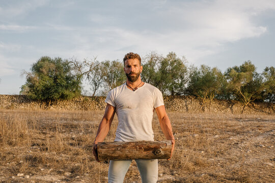 Strong male farmer with log