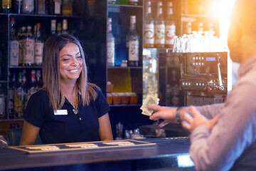 Bartender takes the tip dollar. Bartender girl receives a tip from the client at the hotel bar....