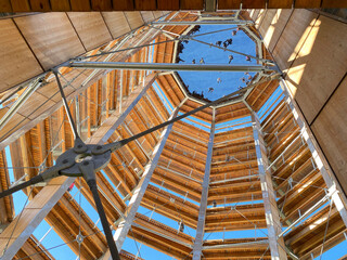 Inside a panoramic tower. Footbridge and observation tower. View on the forest and mountains at fall. High platform, summit path, wooden bridge in the park. Building's construction.