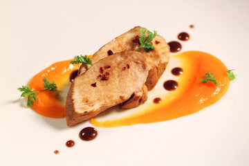 Chicken breast with sauce on a white plate. Side view.