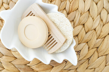 Bar of soap (solid shampoo), loofah bath sponge and wooden hair brush. Eco friendly toiletries set. Natural beauty treatment, skin care or zero waste concept. Top view, copy space.