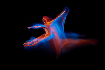 Aspiration. Solo performance of flexible male ballet dancer dancing isolated on dark background in glowing colorful neon light. Grace, art, beauty © master1305