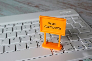 Under construction sign on top of computer keyboard. Computer system under construction,...