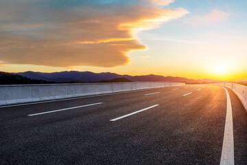 Asphalt road and mountain with beautiful sky clouds at sunset
