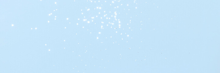 Sparkling silver glitter on blue background banner texture. Abstract holiday blurred lights header. Wide screen wallpaper. Panoramic web banner with copy space for design