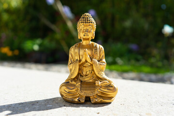Buddha statue near house in front of garden.