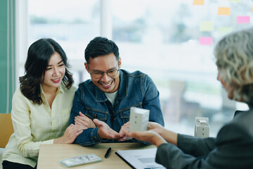 Guarantee Insurance Sign a contract, couple a smiling couple is signing a contract to invest in real estate with the Mortgage officer with the bank