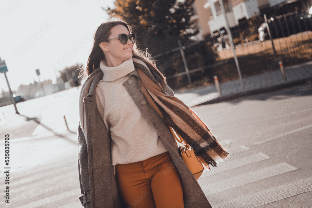 Sticker Photo of cheerful adorable lady dressed warm coat dark eyewear enjoying sunny weather walking university outdoors urban town road