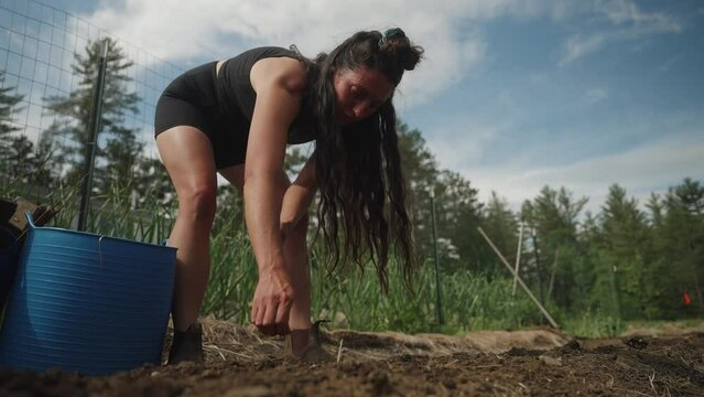 Woman girl farmer planting seeds at farm (4k 30p Slow Motion)