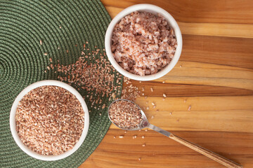 two bowls filled with raw and cooked organic rice - food