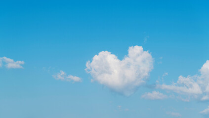 Naklejka na ściany i meble White heart shaped cloud in the blue sky