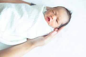 Fototapeta na wymiar Little newborn baby boy in father's hand, close up, newborn baby wrap.