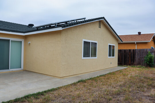 View of the back side of a stucco house freshly painted.