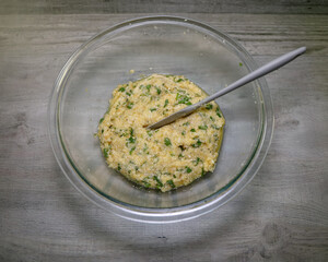 A glass bowl with the mixture for making low carb cauliflower tortillas.
