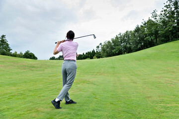 Woman golf player swinging golf club