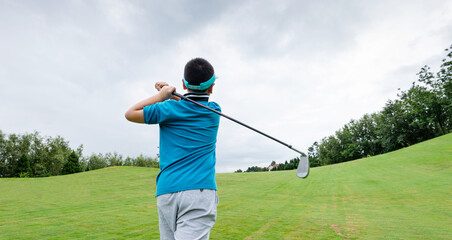 Little boy playing golf on a field