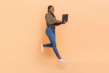 Full length photo of active energetic person hold use wireless netbook isolated on beige color...