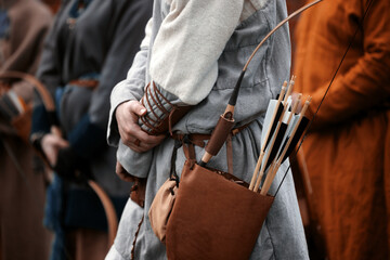 Wooden arrows for the bow. Hand crafted arrows in medieval style. Arrows with feather plumage in archer's quiver. Historical reconstruction - arrows for the bow. Medieval set of archer