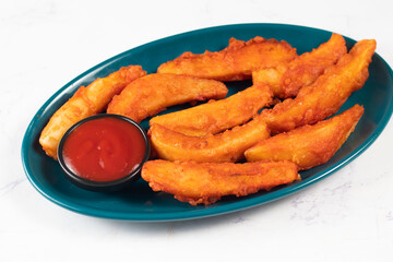 Potatos wedges with tomato sauce served in dish isolated on background side view of fastfood