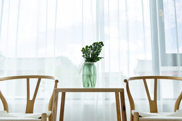 Table and two chairs in front of the window
