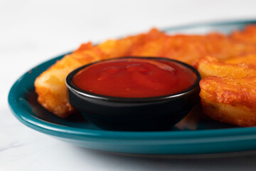 Potatos wedges with tomato sauce served in dish isolated on background side view of fastfood