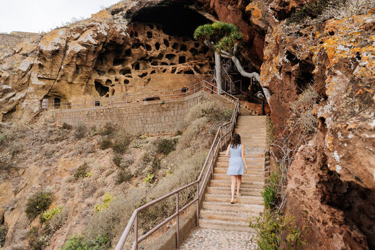 Woman climbing stairs to a volcanic cave