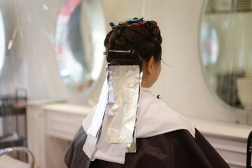 美容室で髪を染める女性