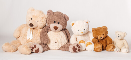 
Teddybären sitzen in einer Reihe auf weißem Hintergrund