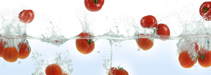 Many tomatoes splashing in water.