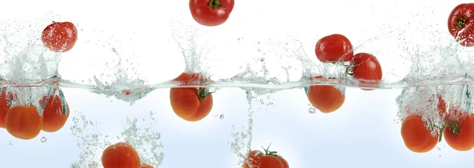 Crédence de cuisine en verre imprimé Légumes frais Many tomatoes splashing in water.