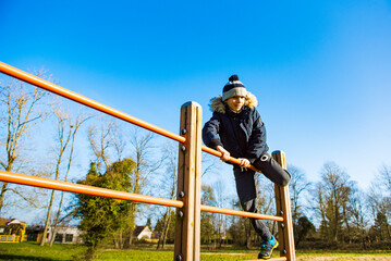 jeune garçon grimpant sur une structure en bois, sport en extérieur