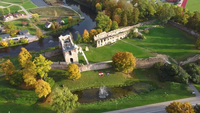 Ruins of an Ancient Medieval Castle Dobele Latvia, Aerial Panorama of Dobele City, Berze River With Fontains and Medieval Castle Ruins With Restored Capella, Latvia. Sunny Autumn Day 4K