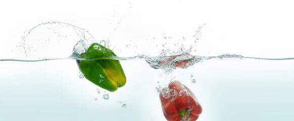 Two peppers splashing in water,