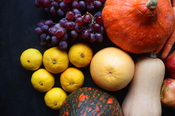 Various fresh and healthy autumnal fruit and vegetable. Top view, dark background.