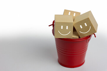 Satisfaction concept, red bucket and wood block with smile face.