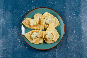 Crispy fried wonthon dim sum wraps with tomato sauce served in a dish isolaed on table top view